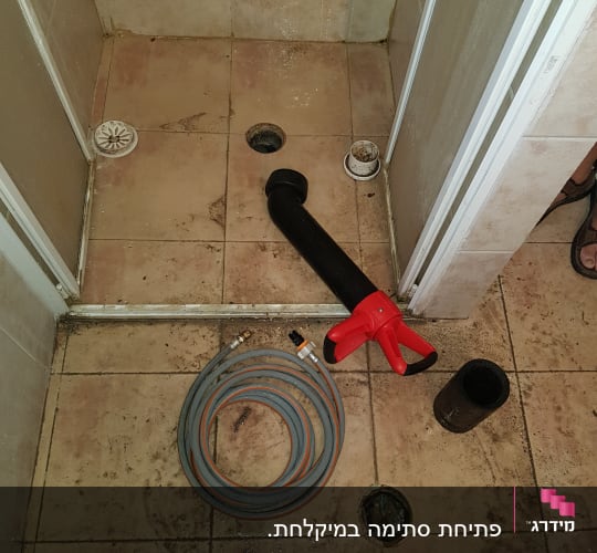 צינור מים וכלי עבודה על רצפת מקלחת
